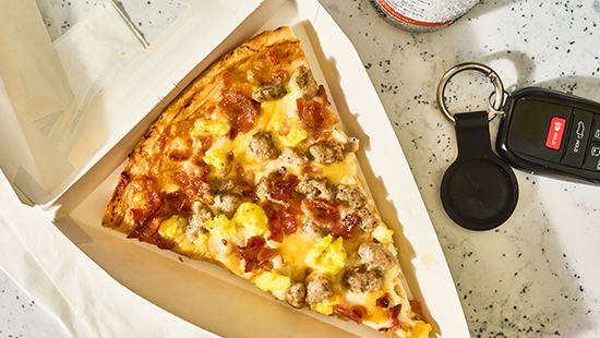 breakfast pizza in to-go box on a counter top