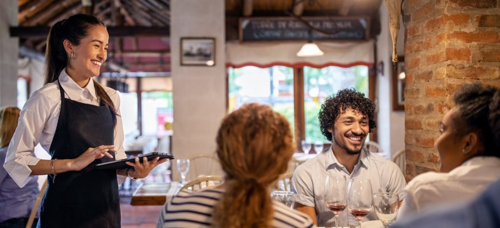 Waiter and diners smiling at each other.