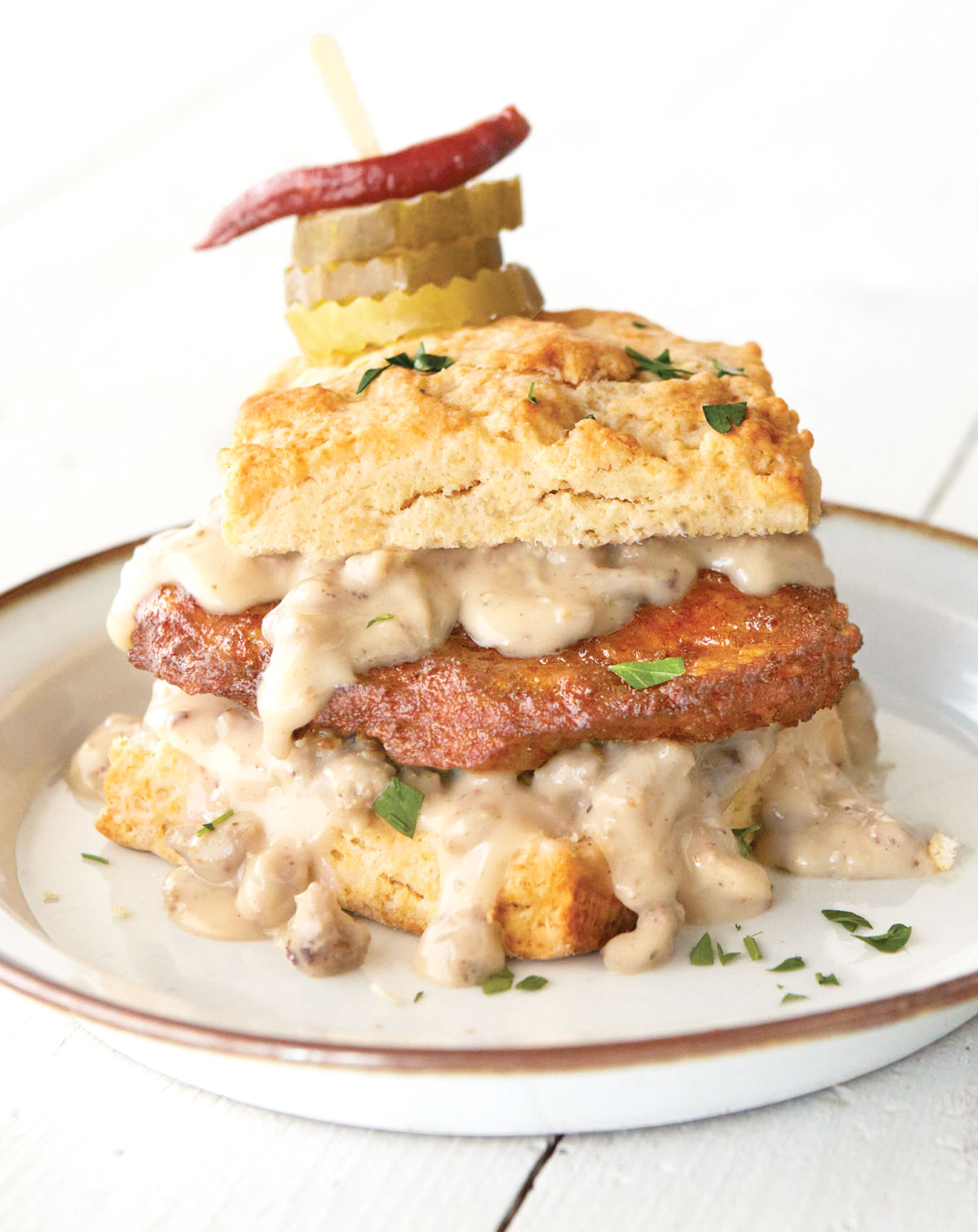battered sous-vide chicken in a biscuit sandwich with gravy