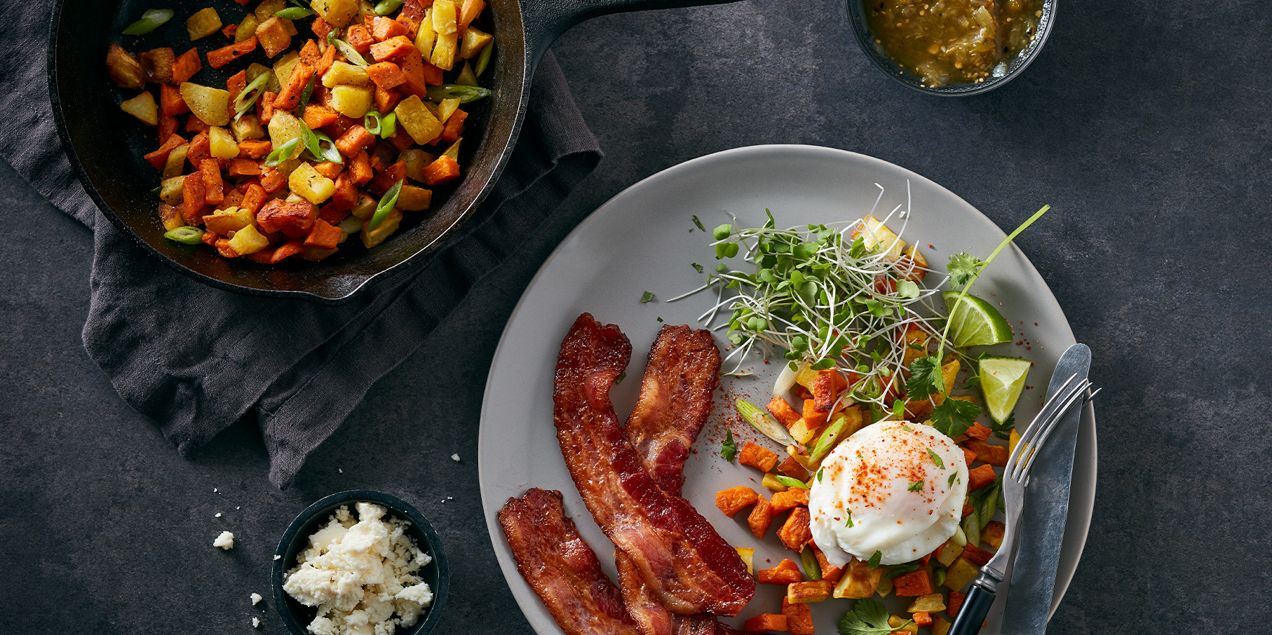 Overhead shot of bacon, egg and veggies on a gray plate
