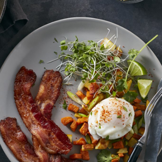 Overhead shot of bacon, egg and veggies on a gray plate