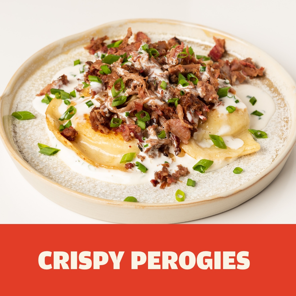 Austin Blues Chopped Brisket nicely piled on top of three buttery perogies with white sauce and green onions plated on a rustic, round ceramic appetizer plate