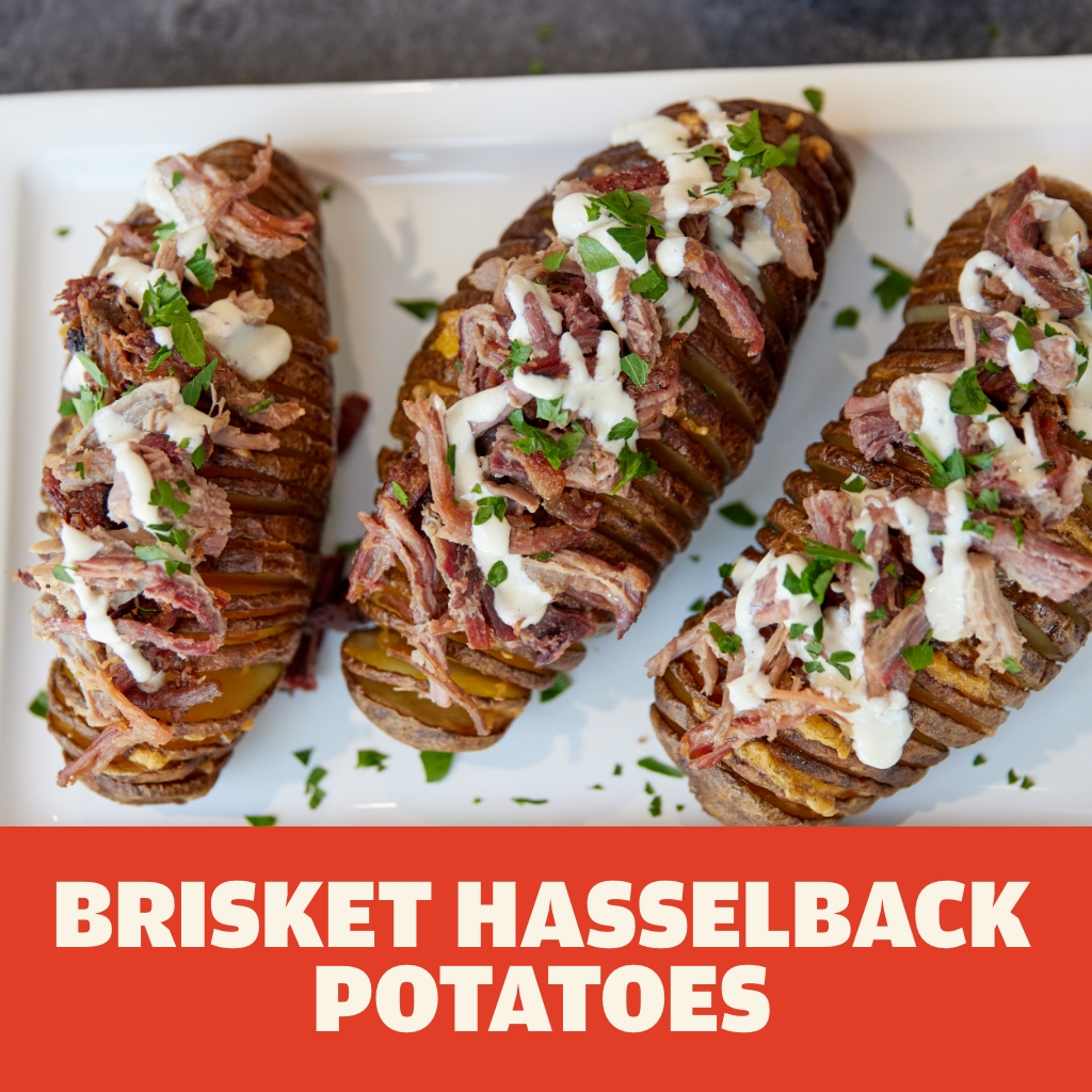 Austin Blues Pulled Brisket on top of three crispy Hasselback potatoes sprinkled with parsley and sour cream served on a white square plate
