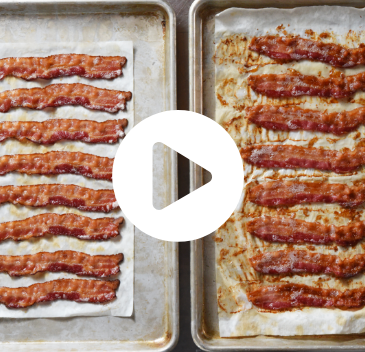 Split image of bacon slides on trays. Bacon 1 is on the left with less grease than raw bacon on the right. There is video play button overlay on the image (click through to see video)