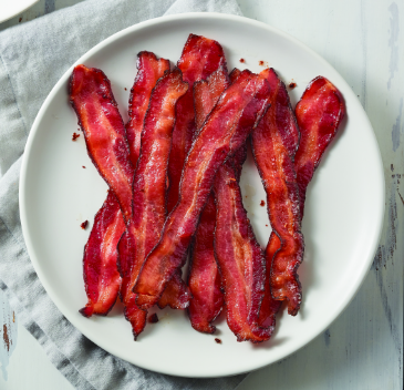 Several whole slices of Hormel Bacon 1 Perfectly Cooked Bacon on a round, white plate
