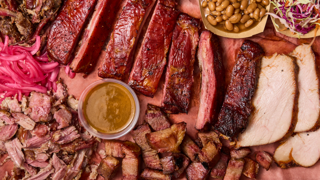 Overhead shot of pit smoked meats, toppings and sauces