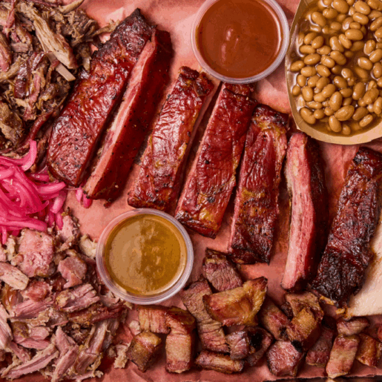 Overhead shot of pit smoked meats, toppings and sauces