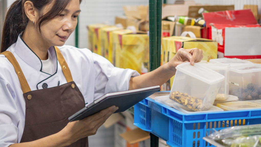 person in an apron taking inventory