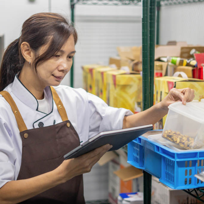 person in an apron taking inventory