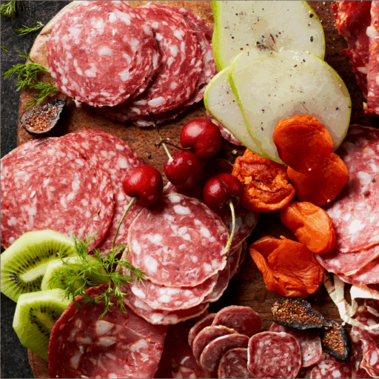 Board with meat, cheese, fruit and garnishes