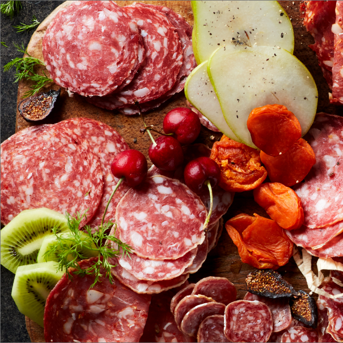 Board with meat, cheese, fruit and garnishes