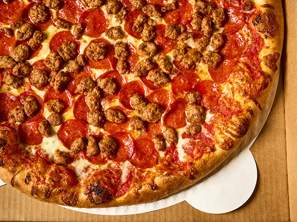 Image of a sausage and pepperoni pizza. 3/4 of the pizza in the shot