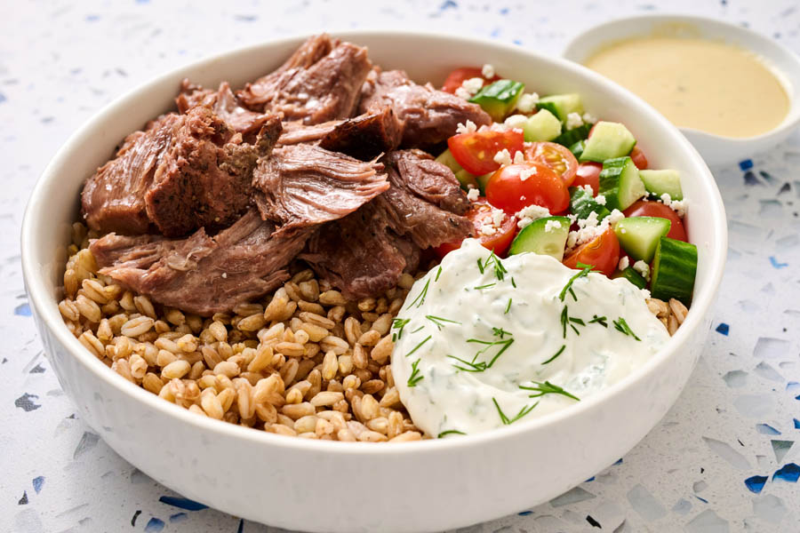 Mediterranean-inspired bowl served with a side of sauce