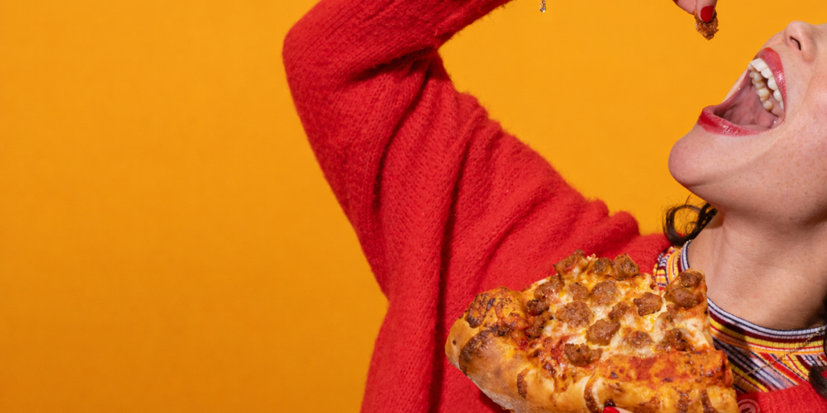 Cropped shot of woman eating pizza.