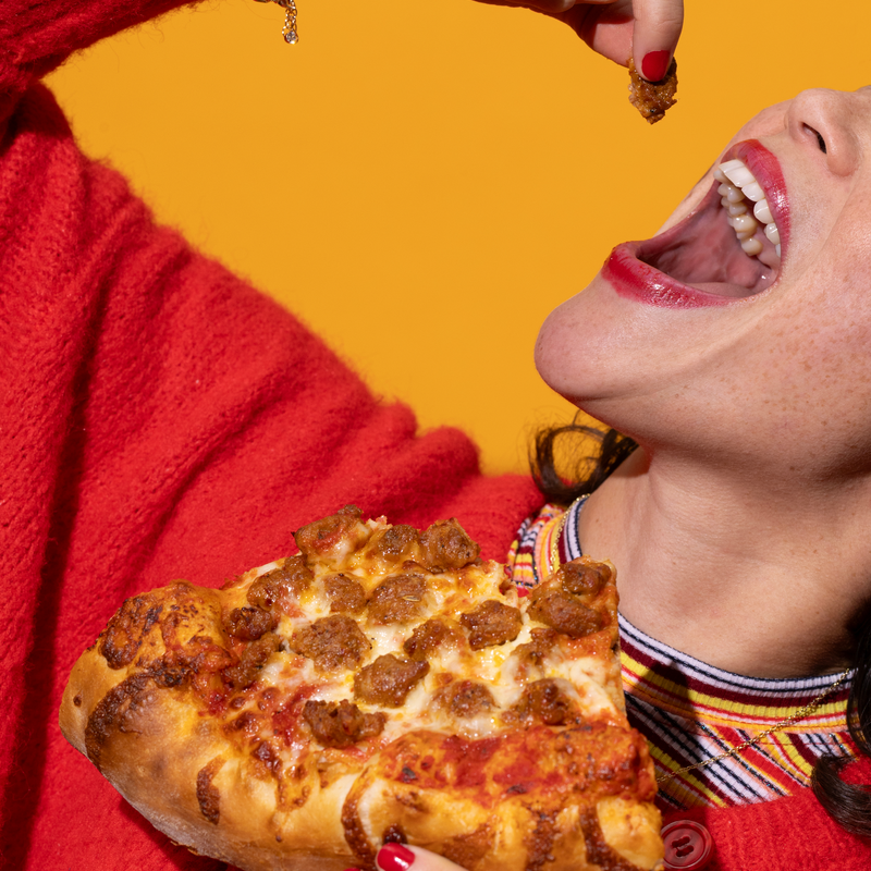 Cropped shot of woman eating pizza.